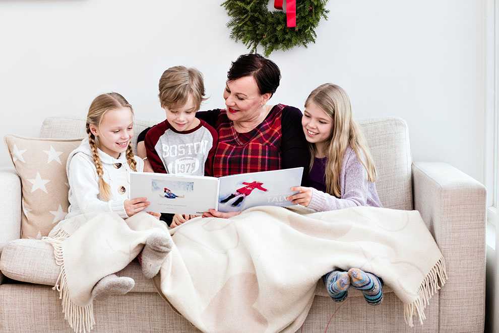 Mummi ja lapset lukevat kuvakirjaa sohvalla Mummi ja lapset lukevat kuvakirjaa sohvalla