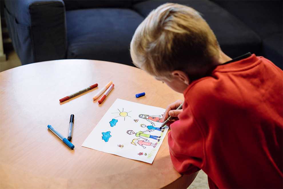 Lapsi piirtää perhepotrettia Lapsi piirtää perhepotrettia