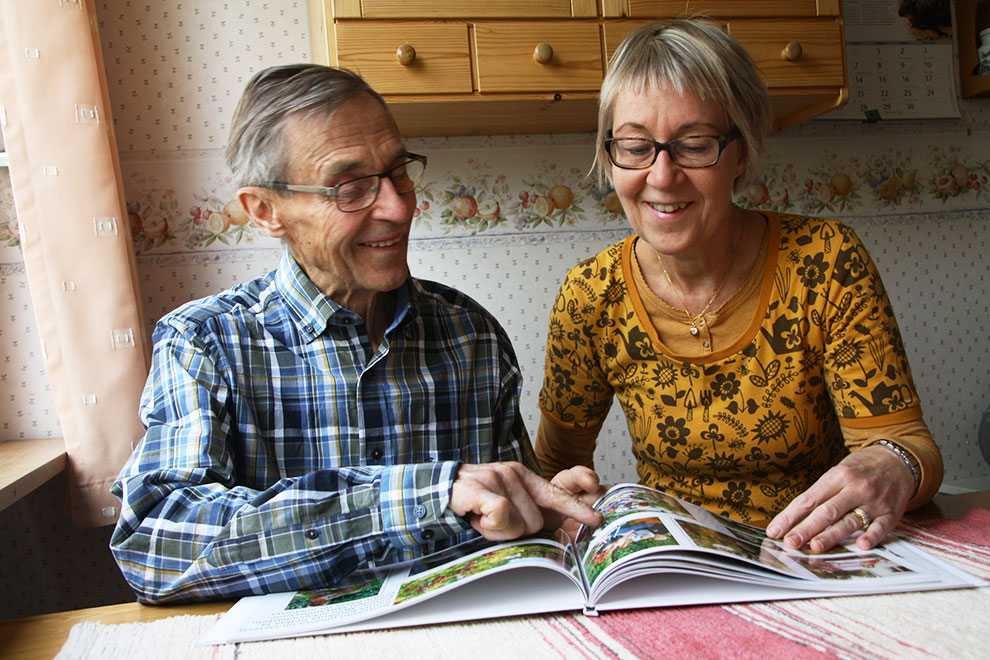 Tiina Yli-Kivistö ja hänen isänsä Erkki Tähtinen selaavat Tiinan tekemää kuvakirjaa Tiina Yli-Kivistö ja hänen isänsä Erkki Tähtinen selaavat Tiinan tekemää kuvakirjaa