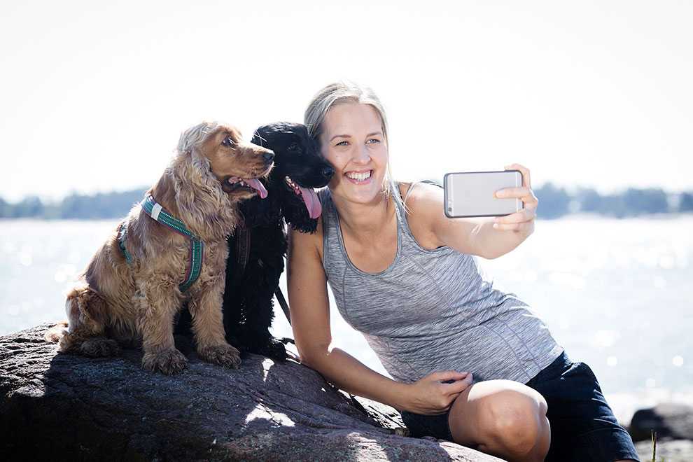 Nainen ottaa selfietä kahden koiran kanssa Nainen ottaa selfietä kahden koiran kanssa