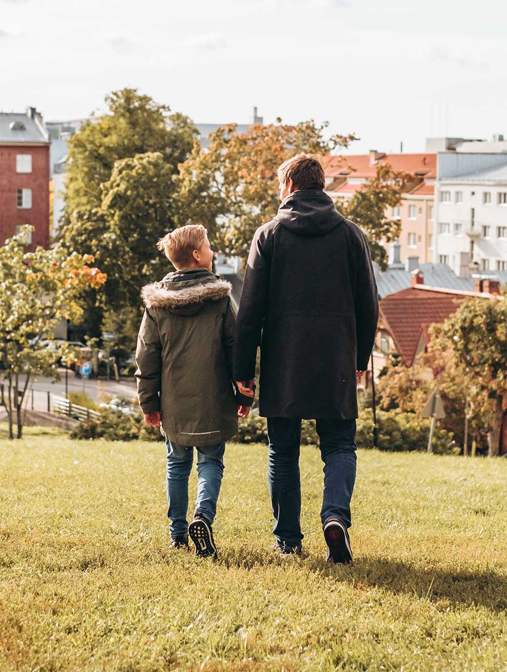Isä ja poika kävelevät puistossa Isä ja poika kävelevät puistossa